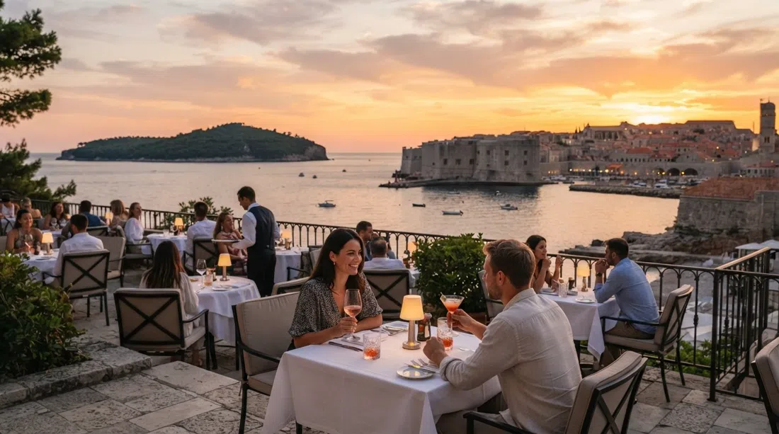 la terraza del Abakus Piano Bar en el Hotel Excelsior al atardecer, mesas con vistas al mar, las murallas y Lokrum al fondo